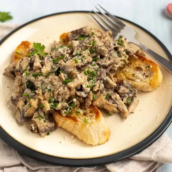 Creamy mushroom toast plated on a ceramic dish